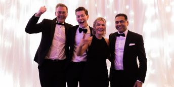 Four individuals pose at a black tie event
