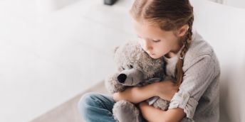 a child hugging a teddy bear