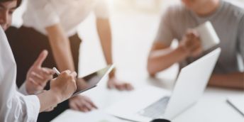 Office workers grouped around a desk