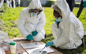 Pupils from Leeds City Academy use brushes to detect fingerprints at a mocked-up crime scene.