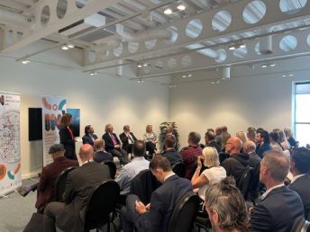 A speaker addresses the audience at an event during a property conference