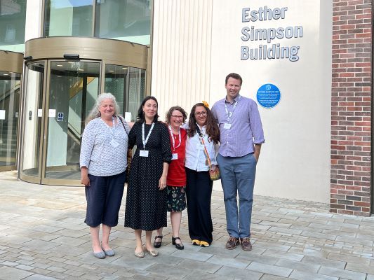 A group of four people stood outside the Esther Simpson Building at The University of Leeds