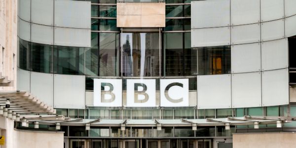 The BBC logo on Broadcasting House, a large, curved, glass-fronted building