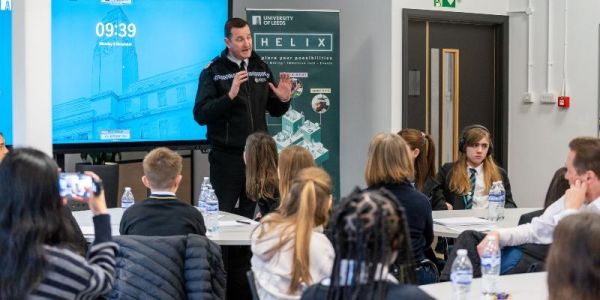 Chief Constable John Robins stands in a classroom in front of young students talking to them about knife crime.