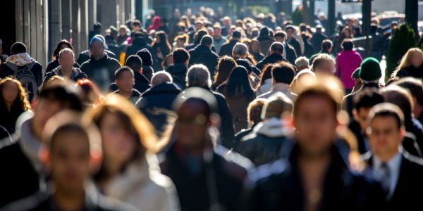 A crowded street, with many people walking to work