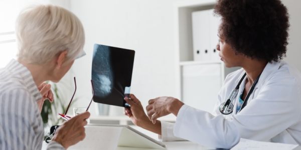 A doctor and a patient looking at a mammogram scan