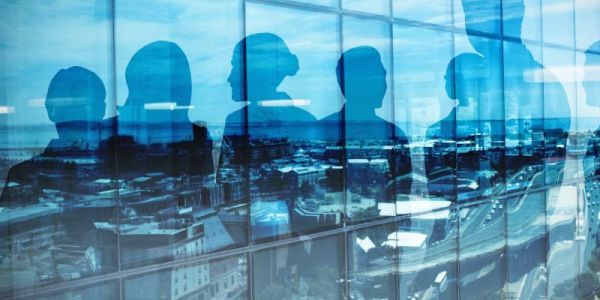 Silhouette of office workers through windows of a high rise office