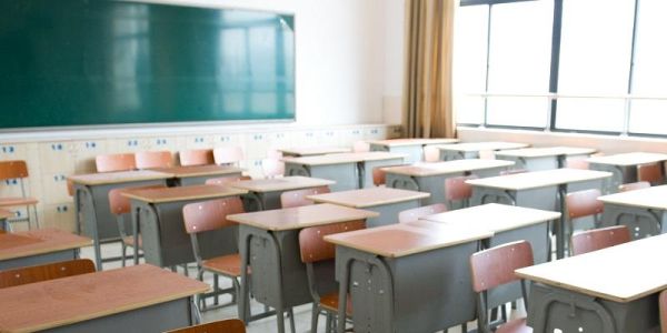 An empty classroom showing a wall with windows