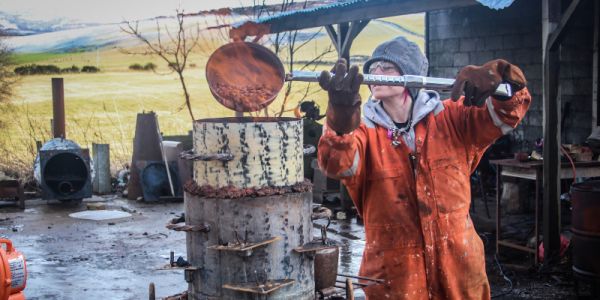 Katie Surridge running her food and smelting furnace at her Scottish Sculpture Workshop residency, 2019