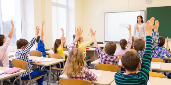 Children raising their hands in a classroom