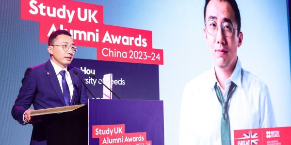 Man at podium in front of a banner saying Study UK Alumni Award
