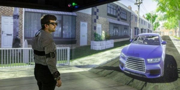 A person wearing virtual reality equipment stands in the University of Leeds' Highly Immersive Kinematic Experimental Research lab