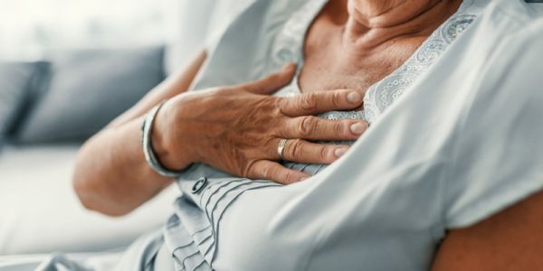 A person's hand on their chest above their heart