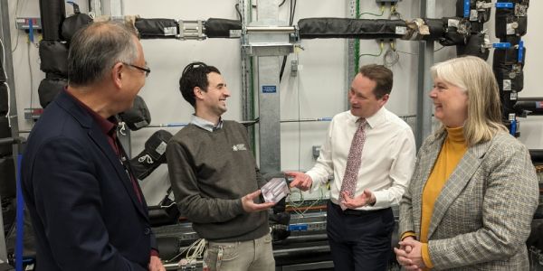 Four members of University staff standing in front of equipment in new nuclear research facility