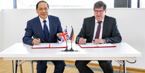 Professor Hai-Sui Yu and Prof. Thomas Hirth sat at a table signing a strategic partnership agreement.