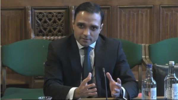 Dr Stuart Flint sitting at a desk, speaking during the Health and Social Care Committee meeting inquiry