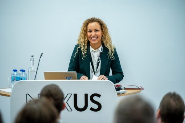 Katie White speaking to a crowd at a lectern