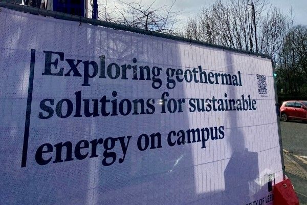 A sign on campus says 'Exploring geothermal solutions for sustainable energy on campus'.