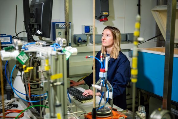 A research looks at a computer screen whilst typing on a keyboard in a lab