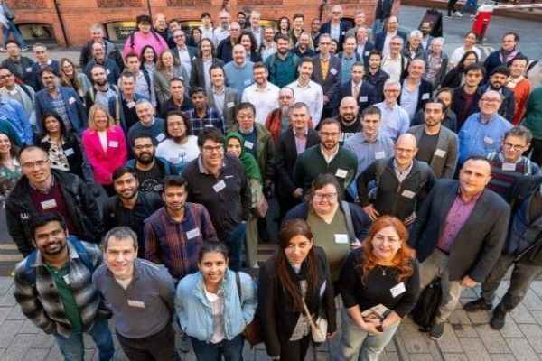 A large group of researchers are looking and smiling at the camera.