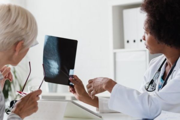 A doctor and a patient looking at a mammogram scan
