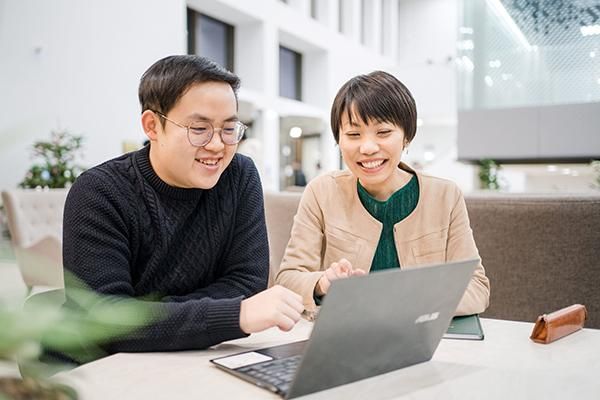 A student and tutor work on a laptop in the Esther Simpson Building cafe