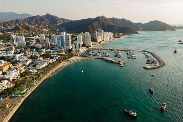 Aerial image of Santa Marta, Colombia. Coast line with skyscrapers on behind beachline and mountains in the distance.