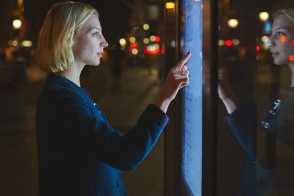 A person using a large touch screen on a street.