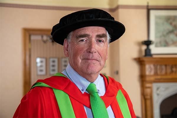 Headshot of David Gray in a graduation gown.