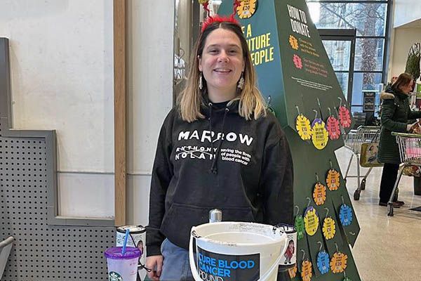 Emily stood smiling on a charity stall.