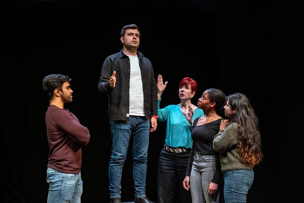 A group of students assess  a person stood in the centre of the group.