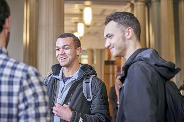 Two students stood chatting in Parkinson Court.