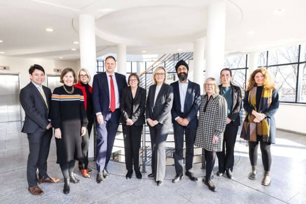 A group of delegates from University of Leeds, including Professor Shearer West, stand together, facing the camera.