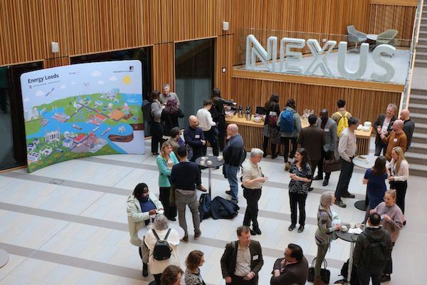 People milling around an atrium with an Energy Leeds banner in background