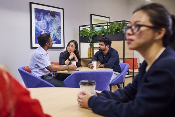 CPD learners sat around a table talking and smiling.