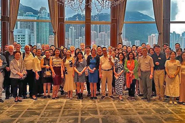 Group in a reception area with Hong Kong skyline behind.