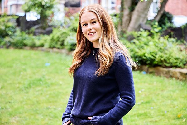 Lottie Low smiling at camera in a green garden