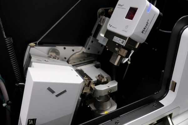 Interior view of the diffractometer, showing its mounted detector head, precision mechanical stages and metal components inside an enclosed chamber.