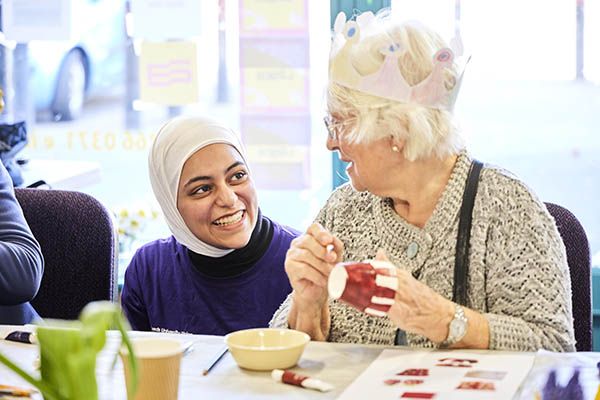 Maryam talking to an older person and laughing.