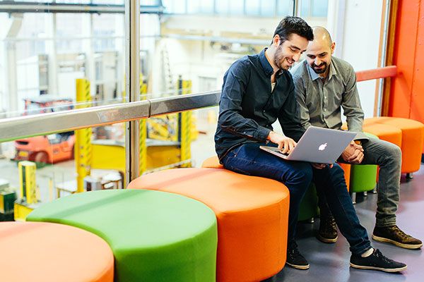 Masters students using a laptop in an industrial space