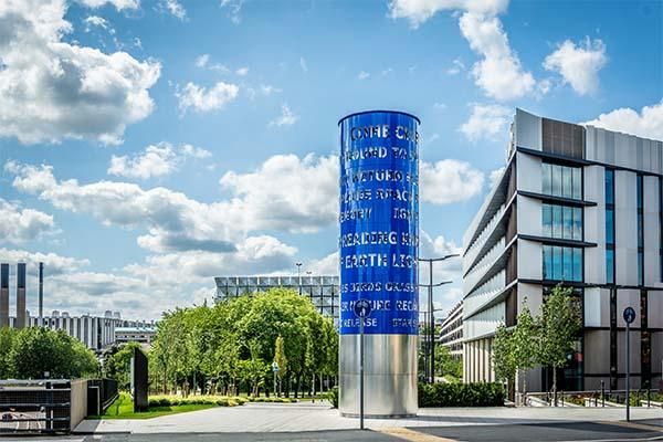 Liliane Lijn's sculpture Converse Column with the Nexus building in the background.