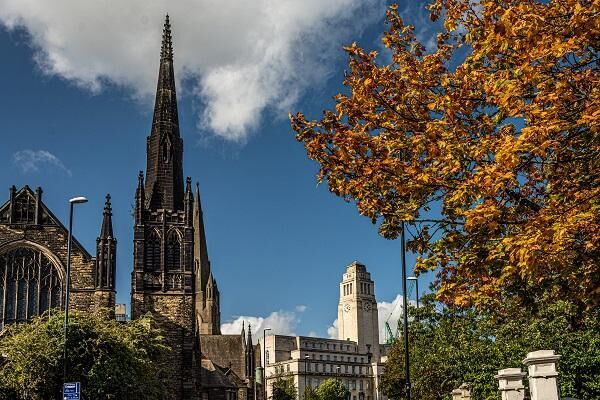 The Emmanuel Centre and the Parkinson Building in Autumn with a tree with orange leaves