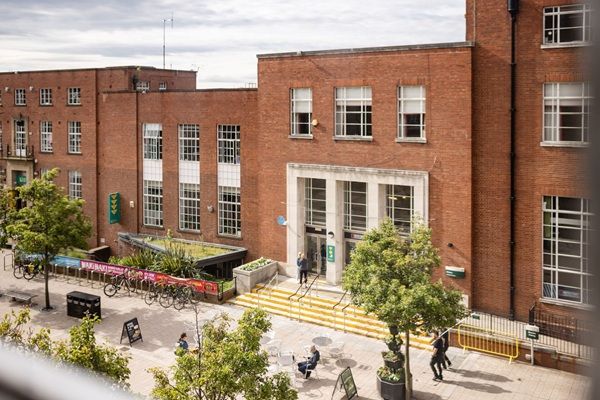 A street view of the University Precinct that shows red brick buildings that host the Leeds University Union and Refectory.