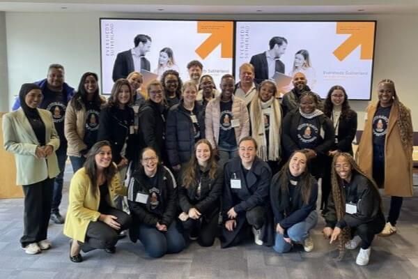 A group of around 20 students from Pretoria and Leeds stand together, smiling at the camera.