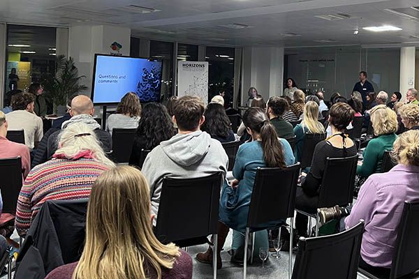 A room of seated people during a question and answer session with the Remaking Places team.