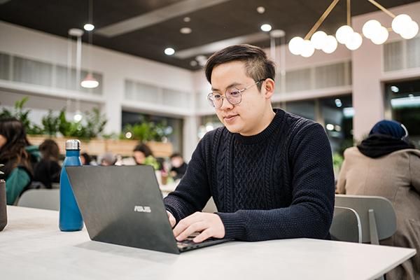 Student using a laptop inside a cafe