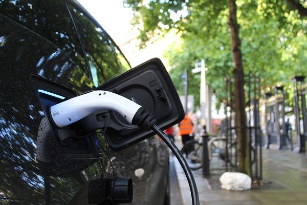 An electric car being charged on the street