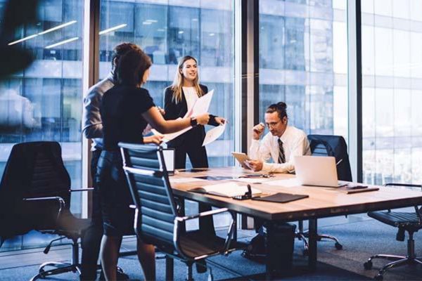 Looking down on an open area of the Nexus building with groups of adults sitting and working together.