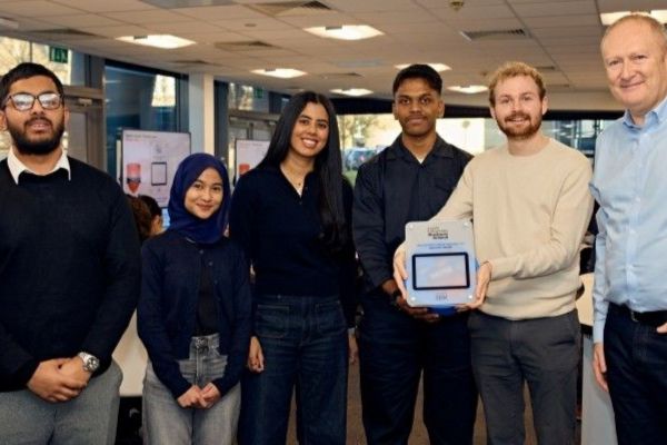 Students and staff at a business pitching event, smiling.
