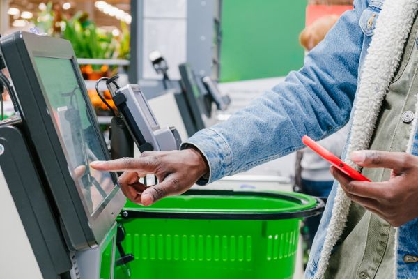 A customer using a self-service checkout in a supermarket.